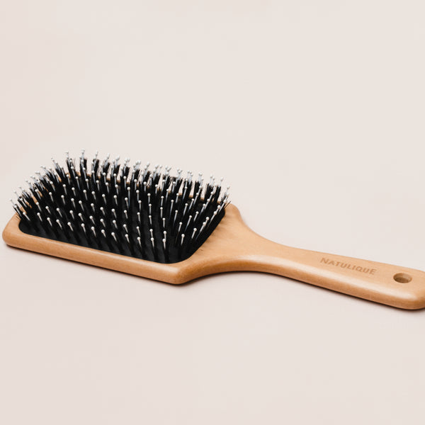 NATULIQUE Professional Paddle Brush with wooden handle and bristles for effective styling and smoothing hair.