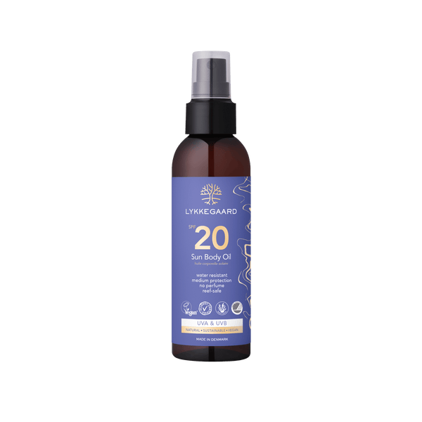 LYKKEGAARD Sun Body Oil SPF 20 in a spray bottle, offering lightweight sun protection and hydration for a radiant glow.
