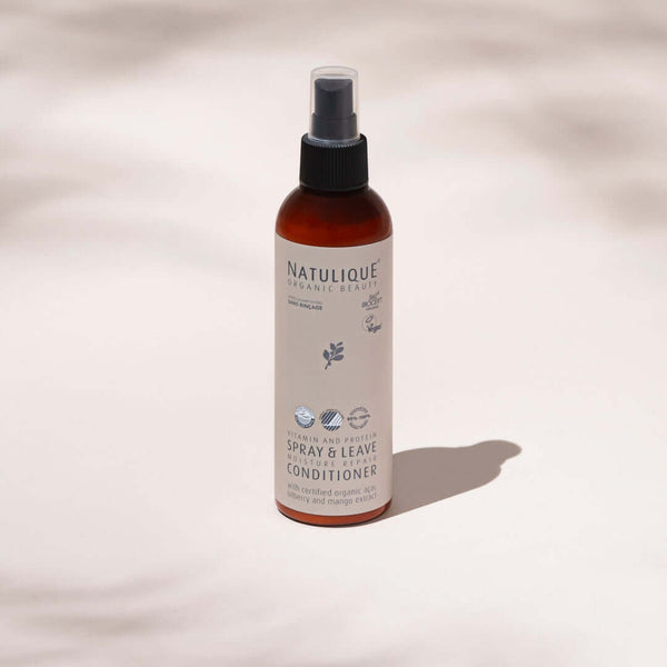 NATULIQUE Organic Spray & Leave Conditioner for hydration and definition of curls and waves in a sleek amber bottle.