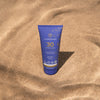 LYKKEGAARD Sun Body Lotion SPF 30 in a blue tube against a sandy background, offering lightweight sun protection.