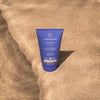 LYKKEGAARD Cooling Kiss After Sun cream tube on sandy beach, providing soothing hydration for sun-kissed skin.