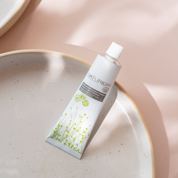 NATURIGIN Light Ash Brown 5.2 ammonia-free hair color tube on stylish ceramic plate, showcasing organic ingredients.