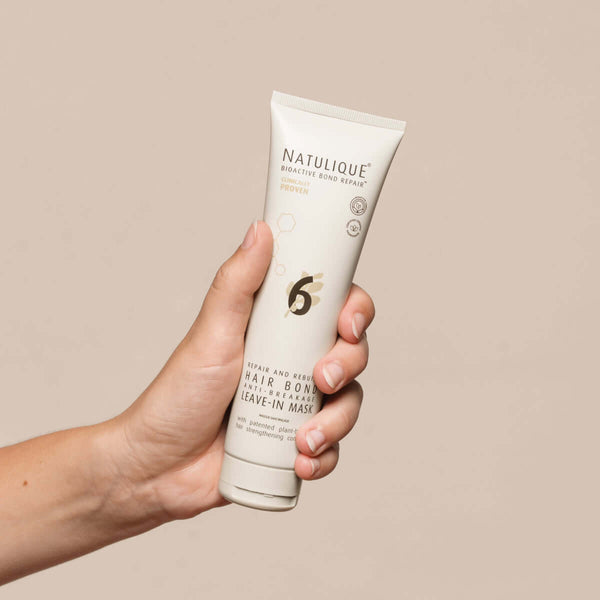 NATULIQUE Hair Bond Anti-Breakage Leave-In Organic Mask No. 6 held in hand, ideal for strengthening and hydrating damaged hair.