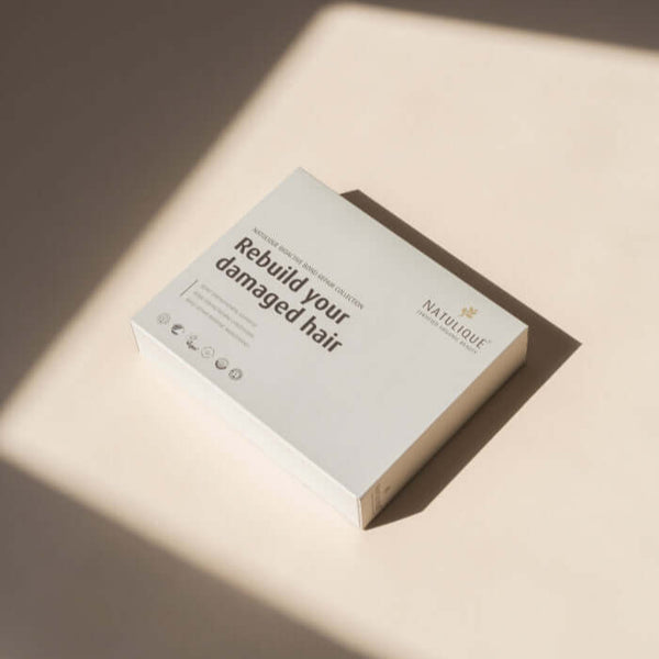 NATULIQUE Bond Repair Gift Set box with the caption 'Rebuild your damaged hair' on a neutral background.
