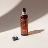 NATULIQUE Organic Rejuvenating Hair Mist bottle with blueberries, 98% organic and sustainable for vibrant hair.