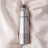 NATULIQUE Ultra Shine Finisher spray bottle on soft fabric background, enriched with organic ingredients for glossy hair.
