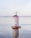 LYKKEGAARD Relaxing Moisture Body Wash bottle reflecting in calm water, showcasing organic hydration for skin.