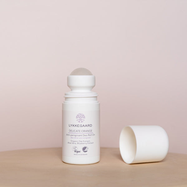 LYKKEGAARD Delicate Orange Anti-perspirant Deo Roll-On on a wooden surface with cap removed.