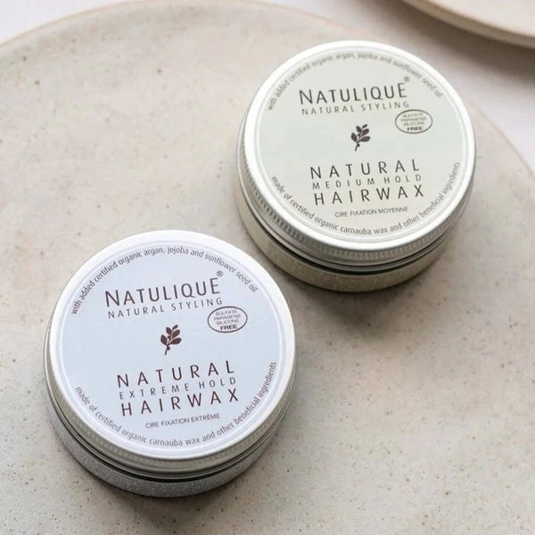 Two NATULIQUE hair wax tins: Natural Medium Hold and Extreme Hold, showcasing 98% organic and sustainable ingredients.